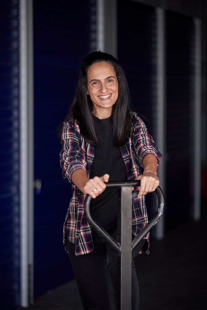 Young woman with moving wheelbarrow organizing her storage room