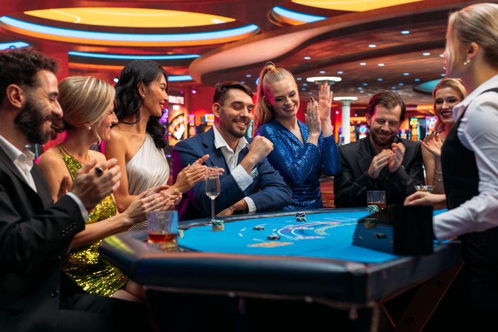 Group of Rich Glamorous People Playing Card at Blackjack Table on a Casino Floor.