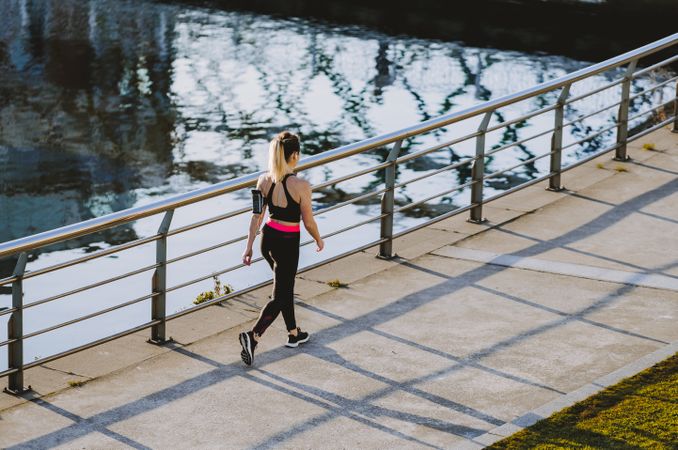 Woman walking on embankment near water