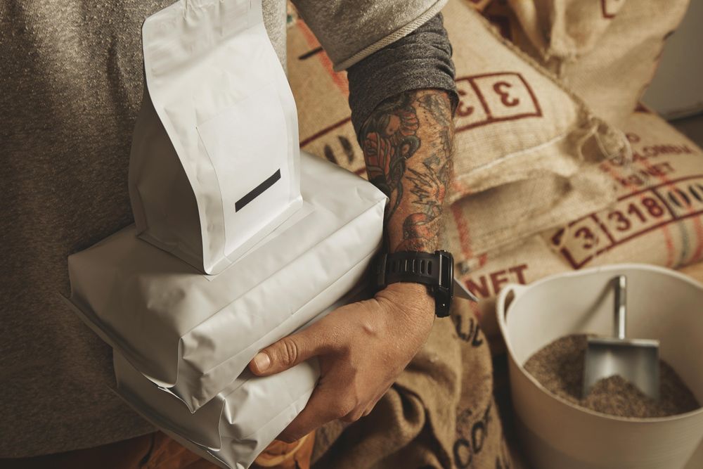 Close up of man holding coffee bean bags