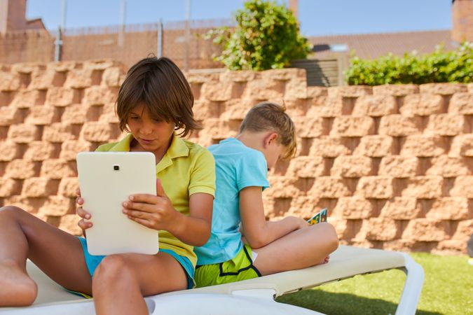 Boys using tablet in garden