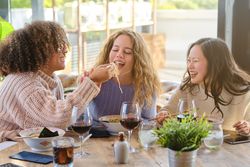 Diverse women having fun while eating ramen in restaurant
