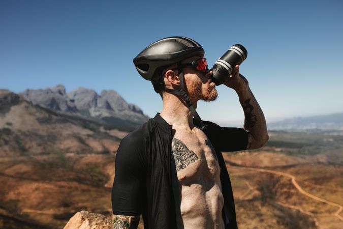 Male cyclist drinking water from bottle