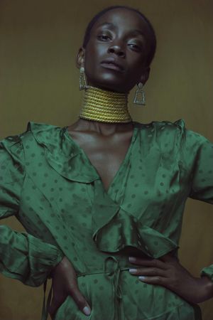 Studio shot of woman wearing green dress and golden necklace