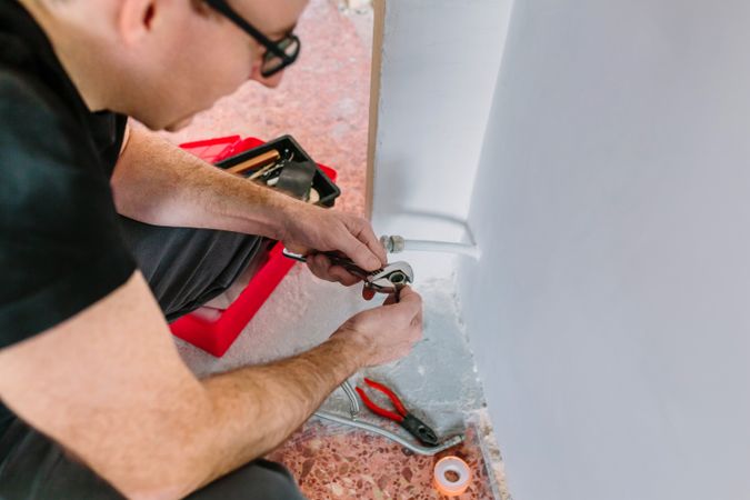 Plumber adjusting spanner to install heating