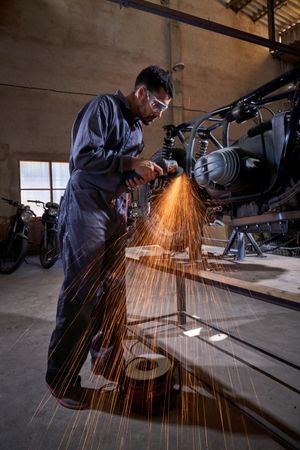 Male mechanic repairing motorbike in garage