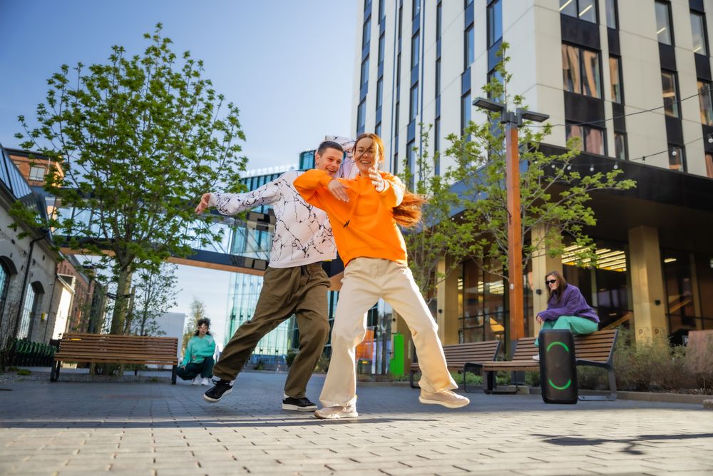 Vibrant Outdoor Scene Capturing Two Young Adults Joyfully Dancing