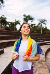 Smiling sportswoman with a towel outdoors on sunny day