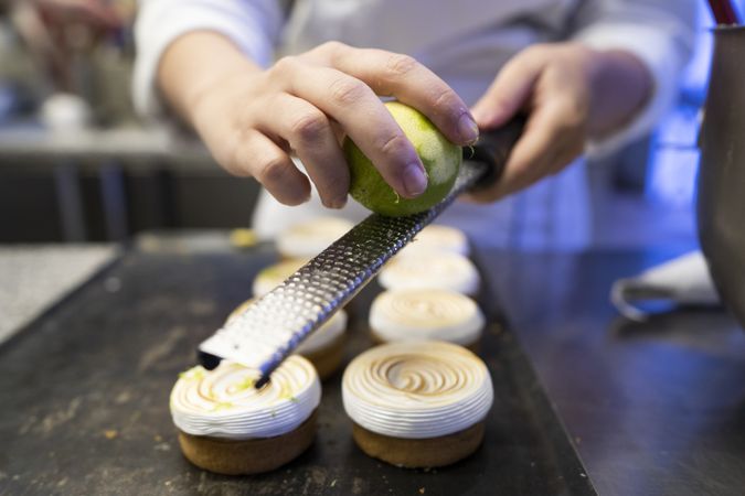 Cook grating lime on meringue cookies