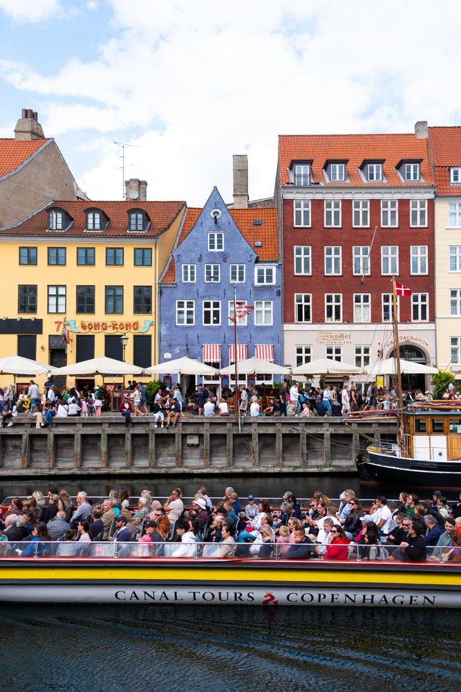 Tourist boat riding past riverfront in Copenhagen