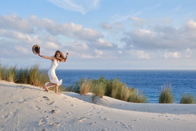 Woman running down sandy hill