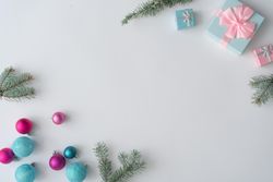 Christmas decorations, gifts with branches on corners of light background