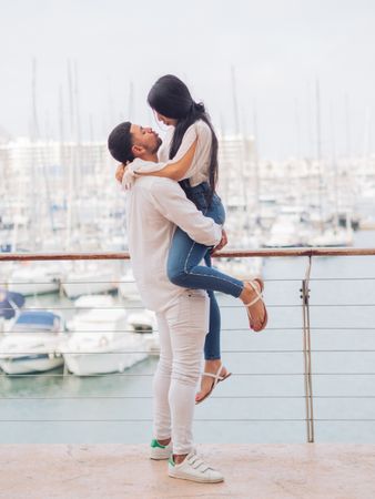 Man raising woman and looking with love