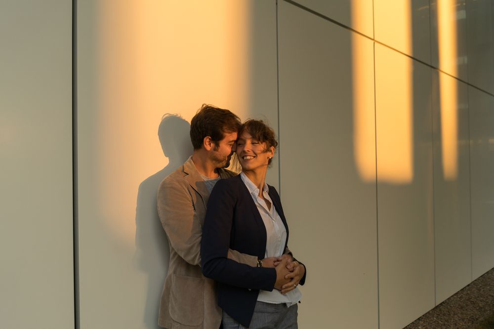 Happy couple colleagues hugging on the street