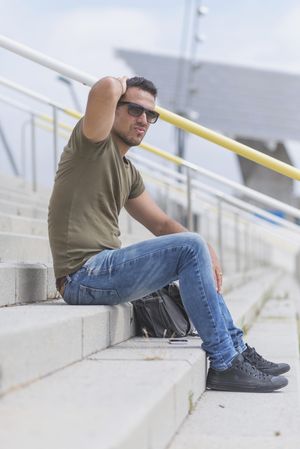 Male sitting on stairs with hand behind head