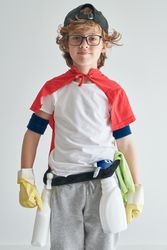 Positive boy wearing costume with detergents standing near studi