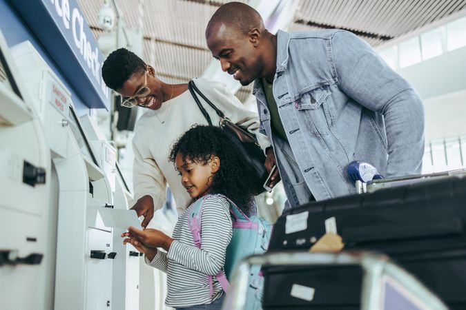 Family at self check-in machine at international airport