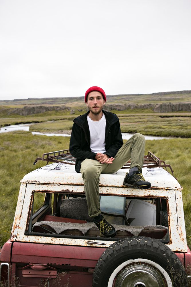 Man sitting on junk yard vehicle