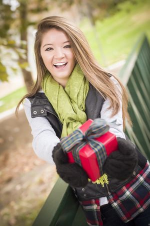 Happy Woman with Wrapped Gift with Bow Outside