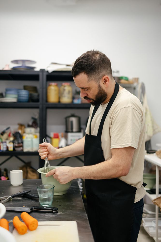 Young chef stirring with cooking rod