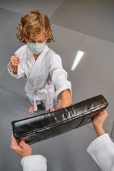 Boy in medical mask doing karate