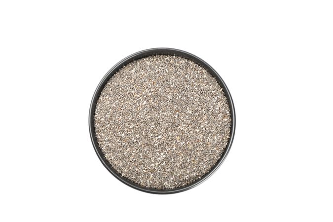 Chia seeds and bowl isolated on studio background