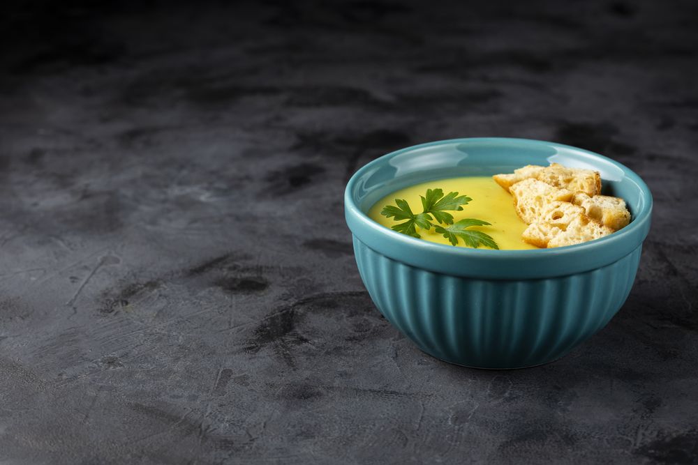 Bowl with onion soup and croutons on the table.