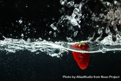 Side view of water splashing on dark background with strawberry 5zMrn0