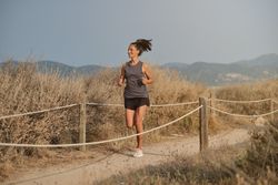 Cheerful woman running in countryside