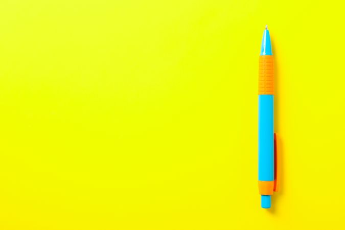 Pen on yellow background, space for text