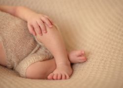 Crop baby lying crossed legs