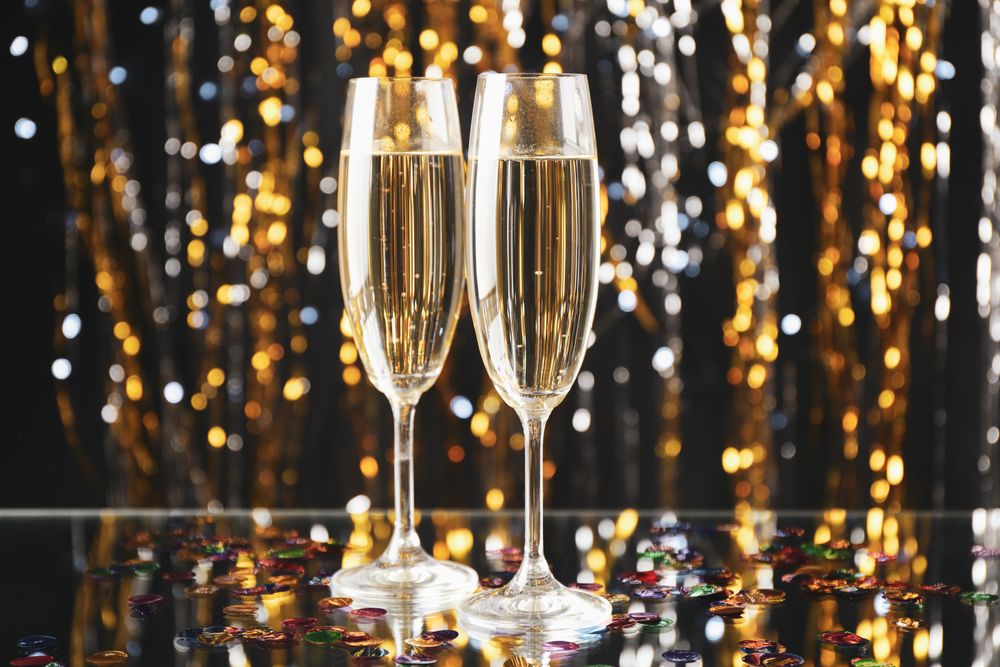 Champagne glasses on blurred background, space for text