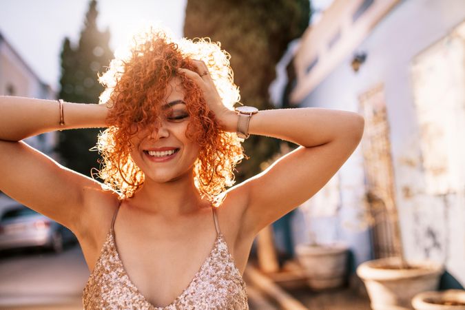Young girl with golden brown hair holding her head in joy