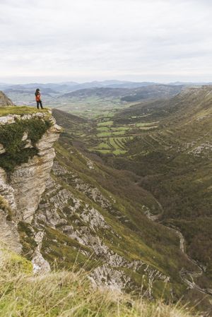 Man standing on cliff near valley