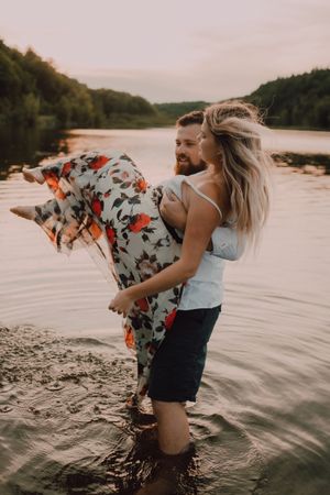 Loving couple standing ankle deep in water on beach