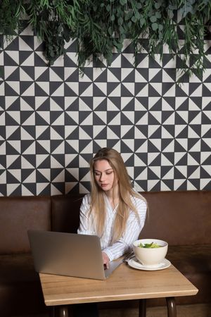 Young woman using laptop in cafe