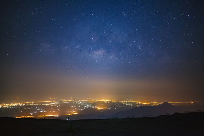milky way galaxy and city light at Phutabberk Phetchabun in Thailand.Long exposure photograph.With grain