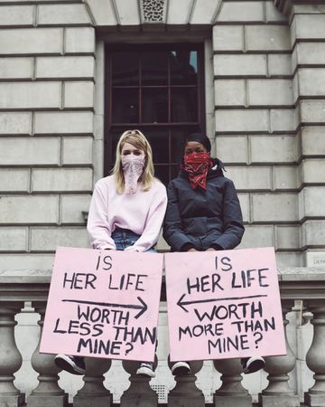 London, England, United Kingdom - June 6th, 2020: Two young women holding opposite signs at protest