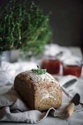 Fresh bread on napkin near tomatoes jam