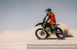 Motocross biker driving bike over sand dunes 41wAp0