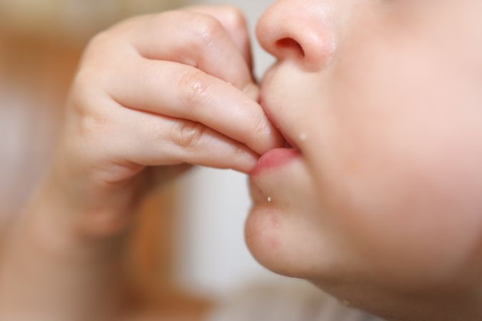 Detail of a small kid learning how to eat healthy by herself.