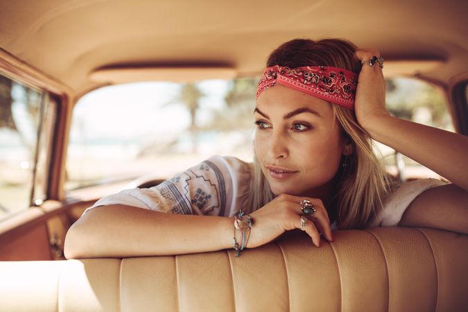 Thoughtful female wearing bandana in a vintage car