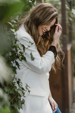 Woman sitting on planter in garden