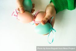 Hands holding pastel egg decorations 4d8AkE