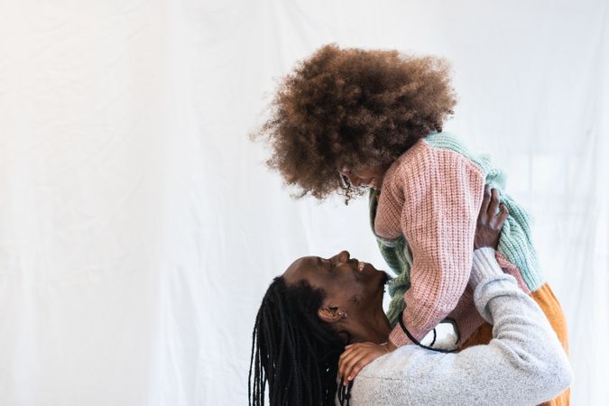 Black man carrying daughter on hands
