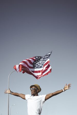 Happy black man with flying American flag