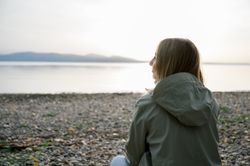 Side view of woman looking away against lake