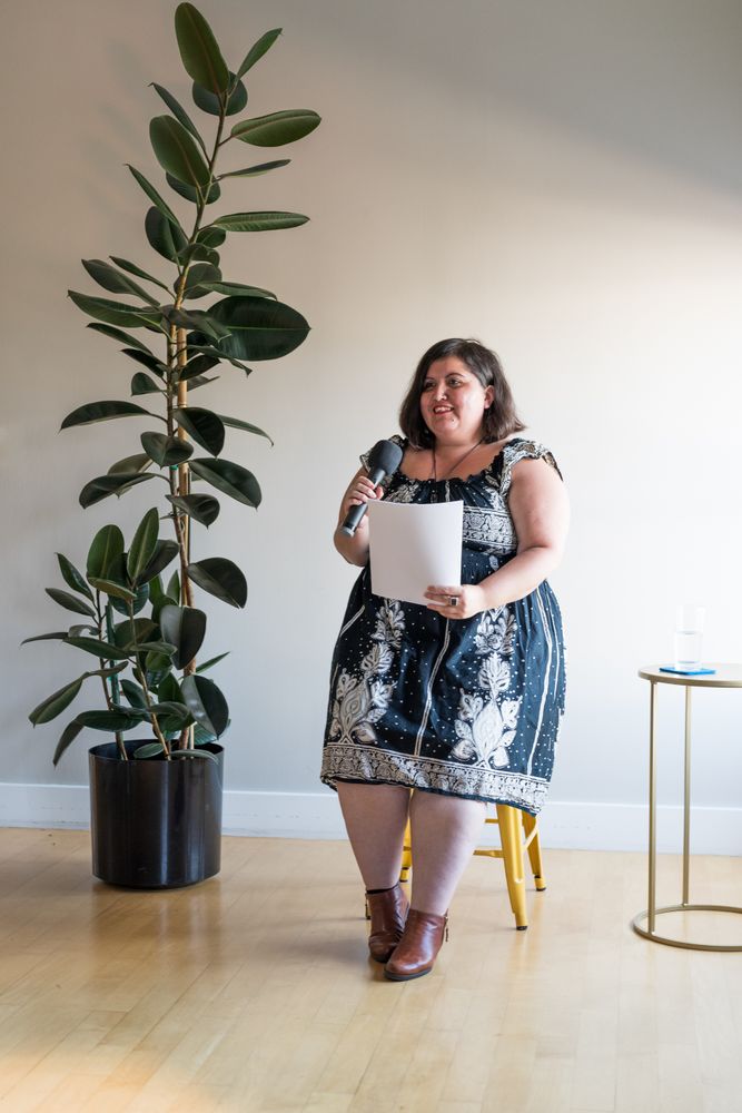 Woman giving a talk with a microphone and her notes
