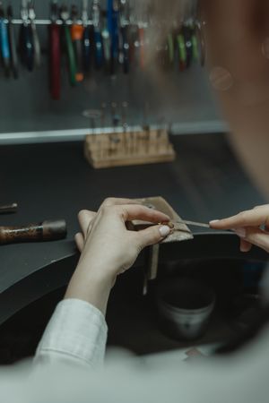 Back view of jeweler making a gold ring