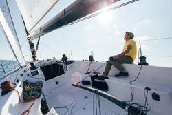 Sailor navigating boat on sunny day
